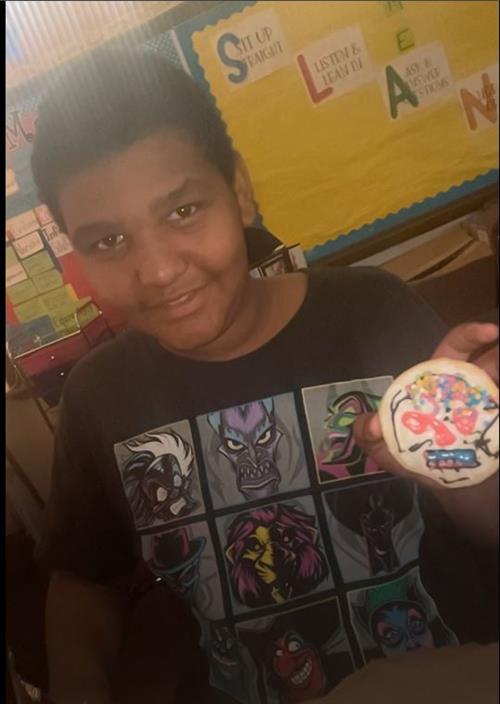  Eighth grade student holding a decorative skull cookie